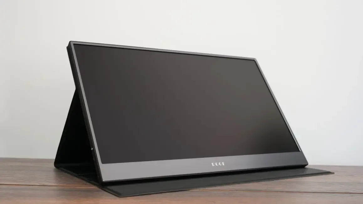 Portable touchscreen monitor on a wooden desk, angled front view